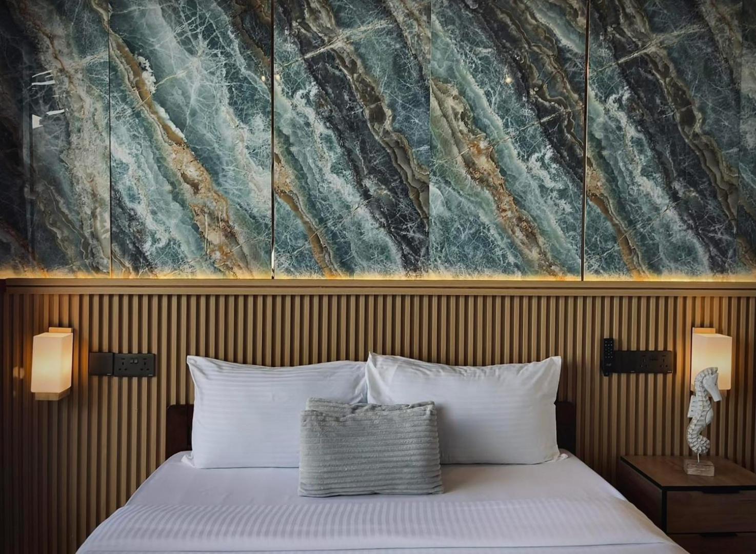 An elegant bed inside a gorgeous bedroom at Seaweed Village in the Celebes Sea featuring swan towel art, a gold runner, elegant hardwood floors, and air con.